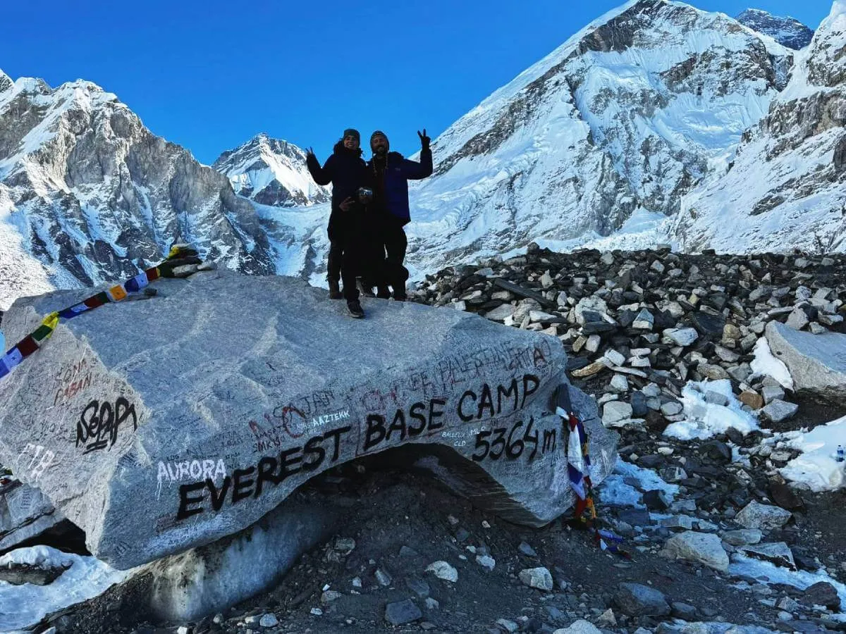 Trekker standing on Everest base camp iconic stone