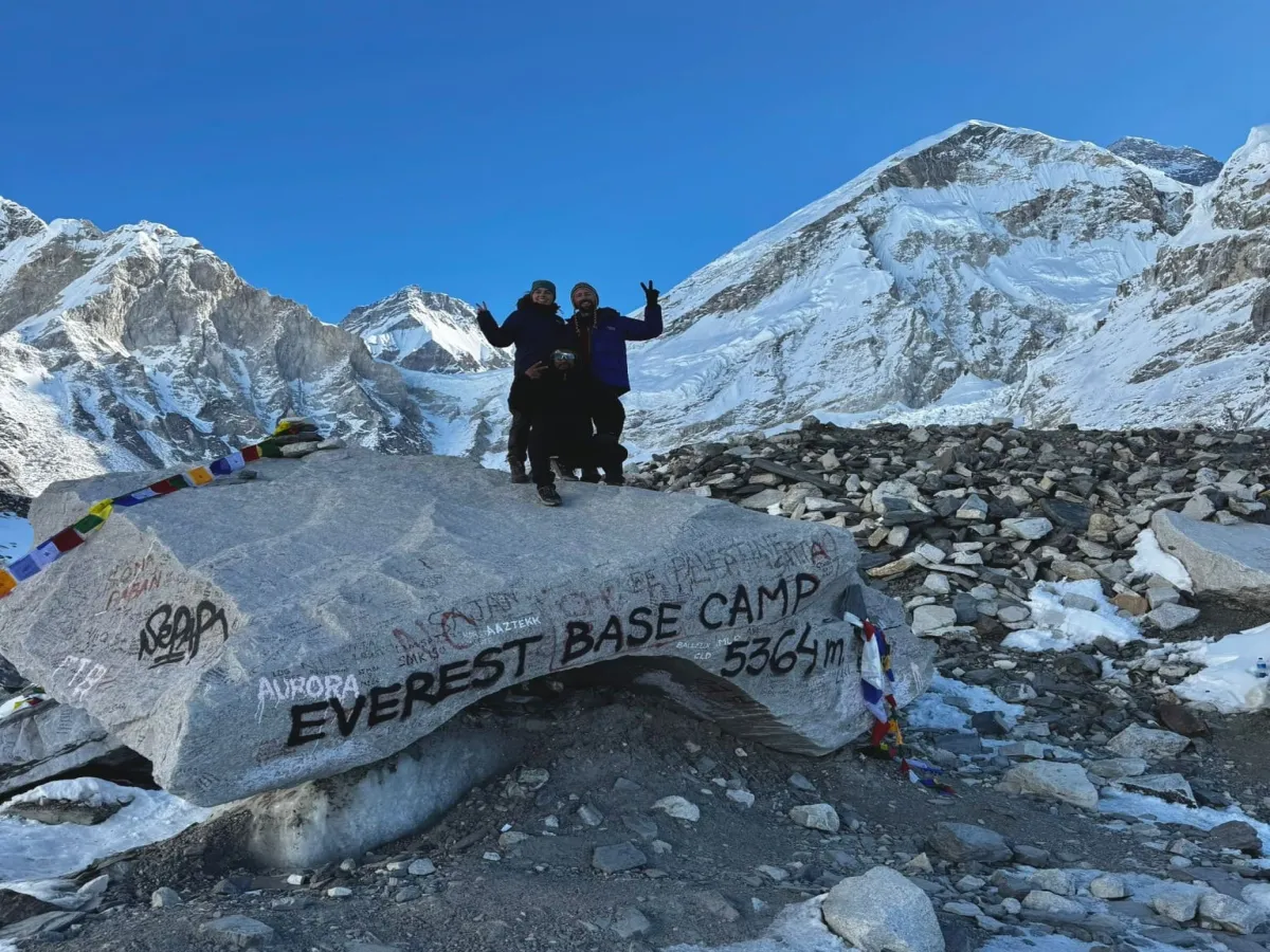 Trekker standing on Everest base camp stone