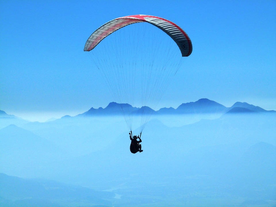 Paraglider flying over Pokhara valley with the Annapurna mountain range in the background.