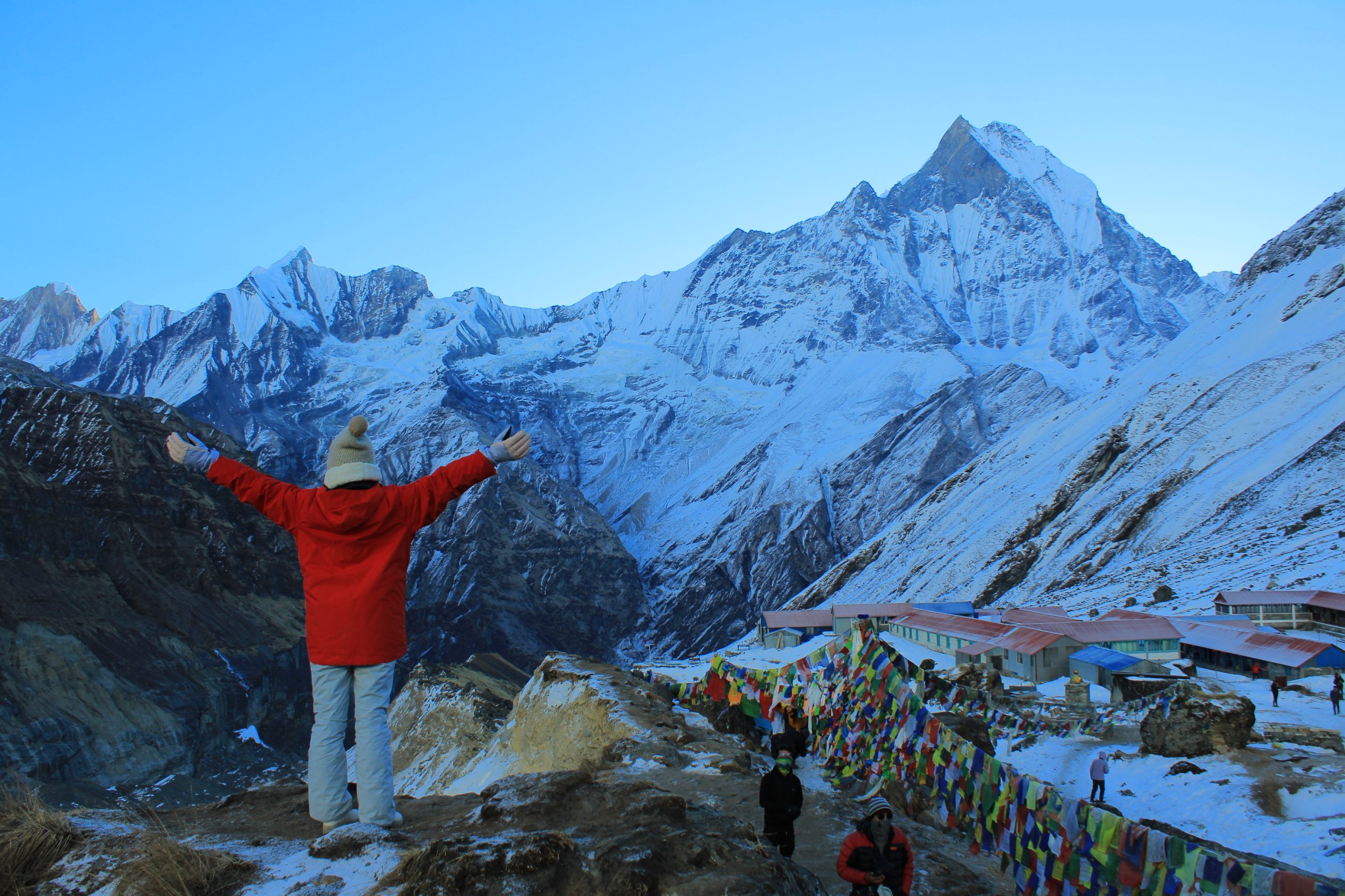 Trekkers standing at Annapurna Base Camp with the majestic Annapurna mountain range in the background.