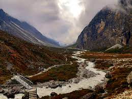 River flowing through Rolwaling Valley with alpine meadows and mountain peaks.