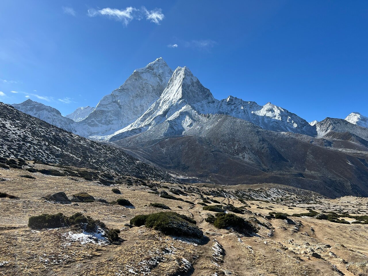 Trekkers on the Everest Base Camp trail with Mount Everest in the background.