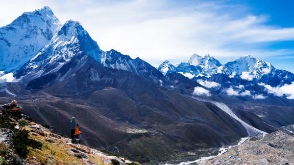 Panoramic view of the Annapurna mountain range with snow-capped peaks against a brilliant blue sky.