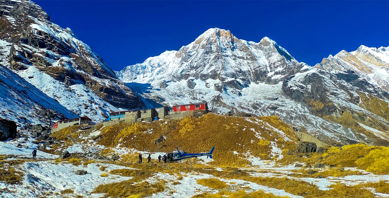 Helicopter landed at Annapurna Base Camp with the Annapurna mountain range in the background.