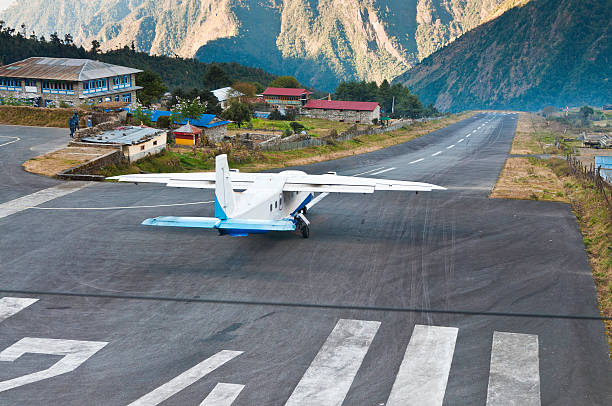 Lukla Airport, a tiny alpine airport with a short runway surrounded by hills and Himalayan peaks.