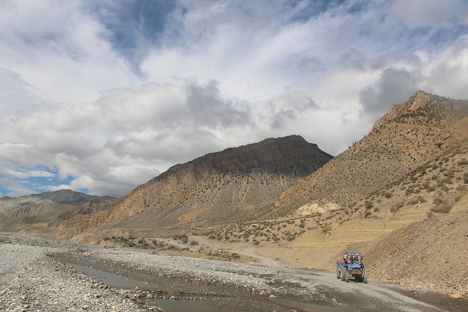 Arid hills and rugged terrain of Jomsom with the Annapurna mountains in the background.
