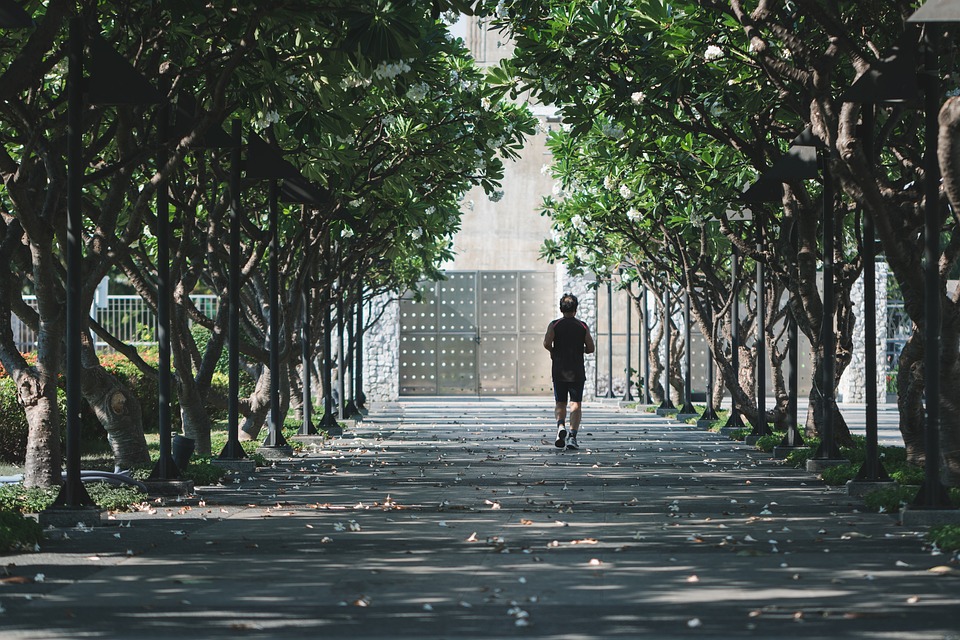A person running outdoors in athletic gear with scenic background, symbolizing exercise and fitness.