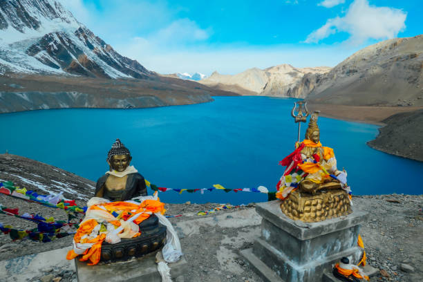 The serene Buddha idol stands gracefully before the breathtaking Tilicho Lake, a symbol of peace amidst the majestic Himalayas.