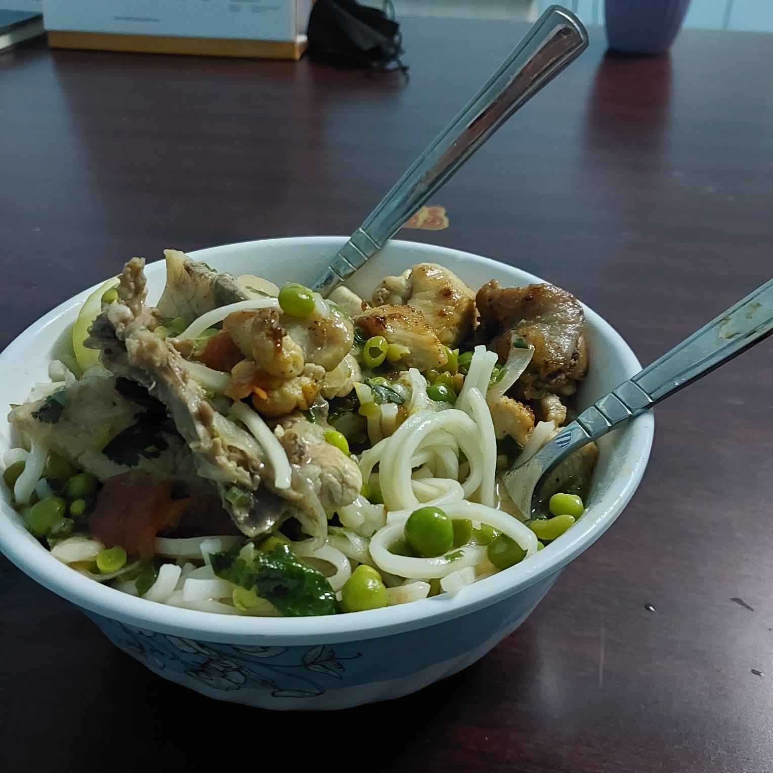  A steaming bowl of Thukpa, a Tibetan noodle soup with vegetables and meat, served in a traditional bowl.