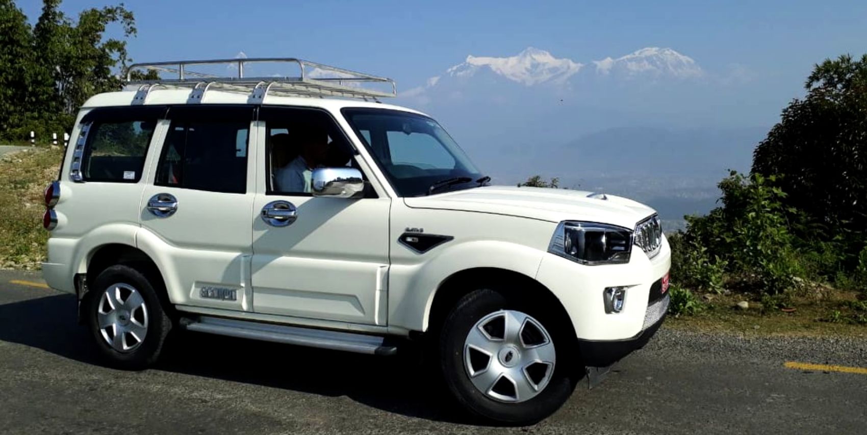 A rugged Scorpio vehicle parked against the breathtaking backdrop of the Himalayas, ready for the adventure ahead.