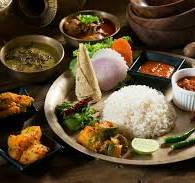 Traditional Nepali meal served on a plate with rice, lentils, vegetables, and pickles.