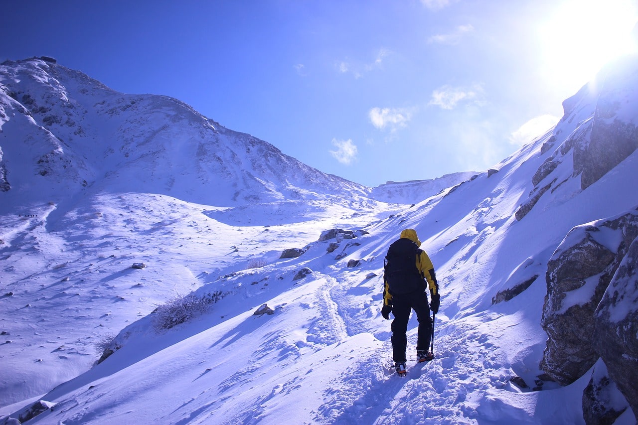 A lone trekker makes their way through the rugged Himalayan trail, surrounded by breathtaking mountain vistas.