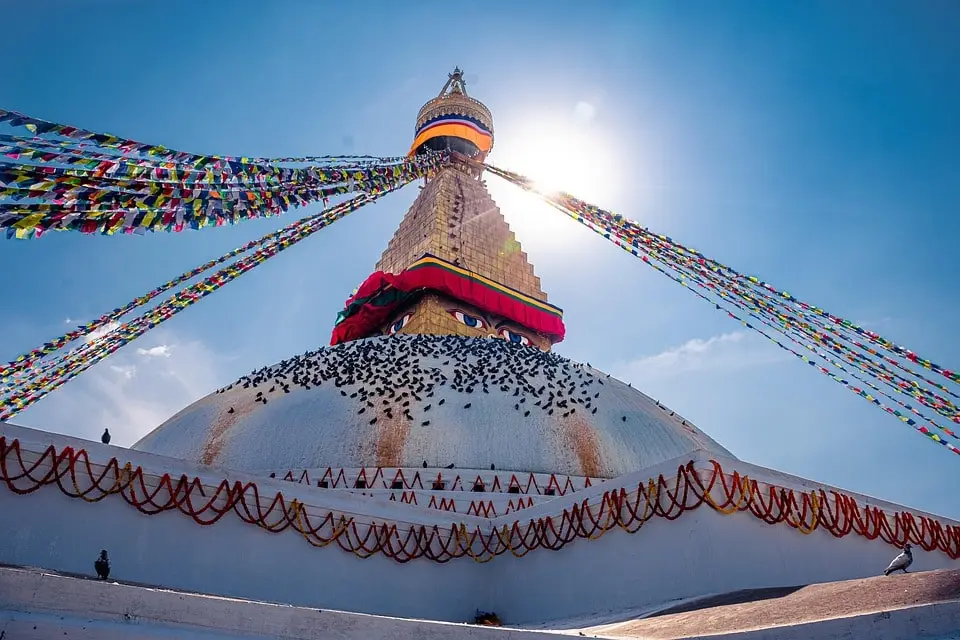 Boudhanath Stupa in Kathmandu with prayer flags and pilgrims, a cultural landmark before starting the Annapurna Circuit Trek.