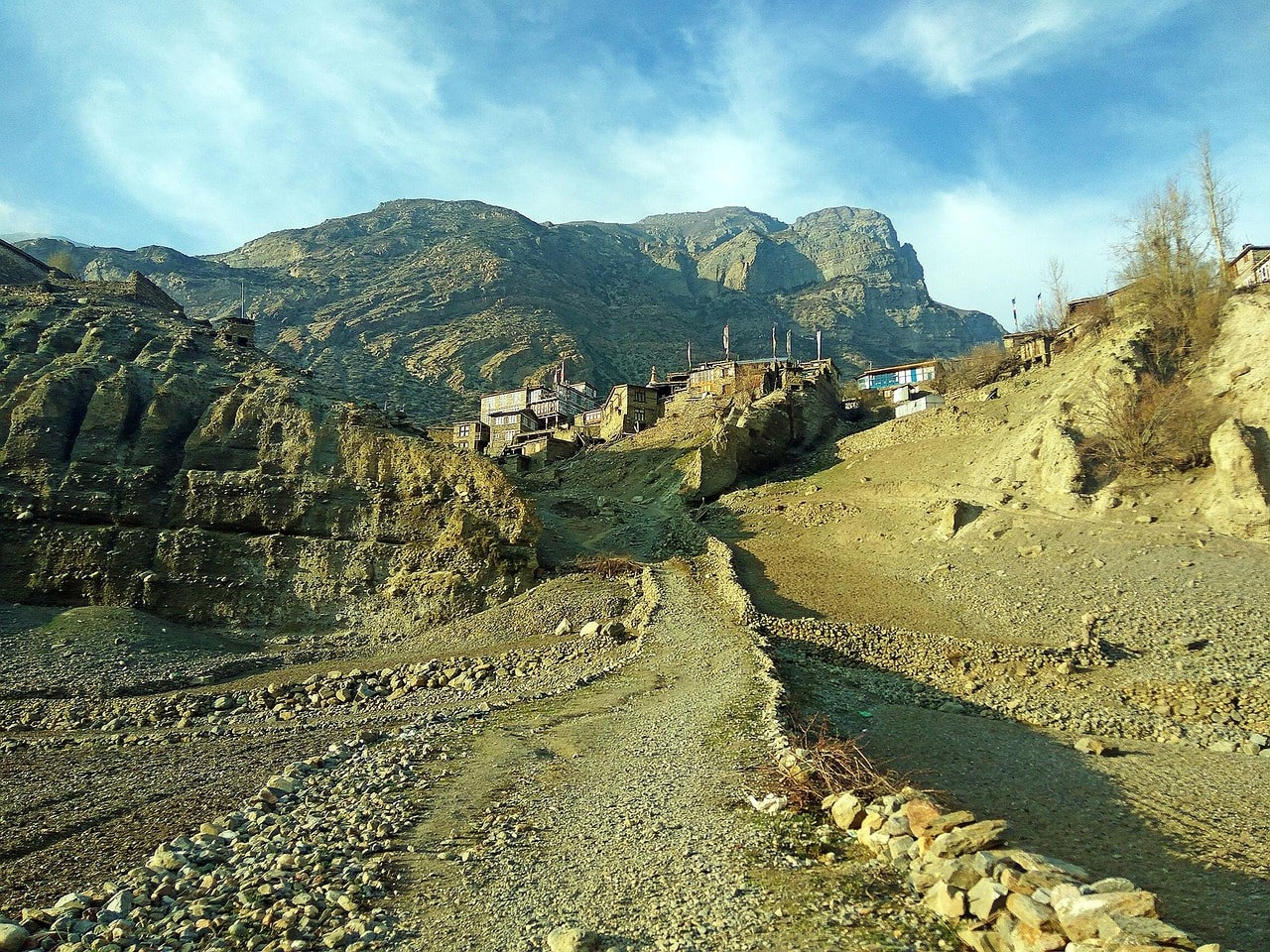 Scenic view of Manang Valley with snow-capped peaks, green meadows, and traditional villages along the Annapurna Circuit Trek.
