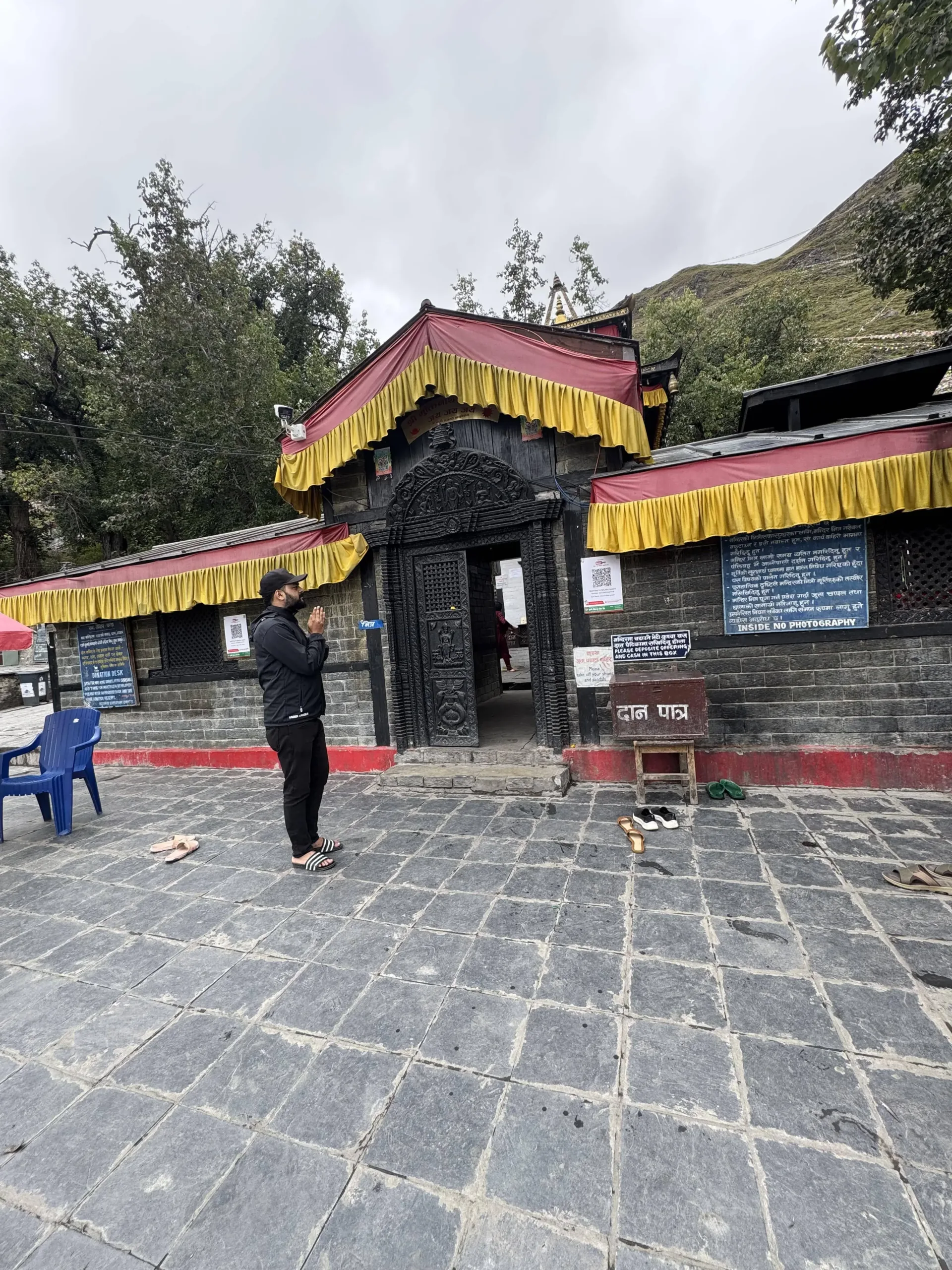 Trekker praying at Muktinath Temple during the Annapurna Circuit trek in Nepal.