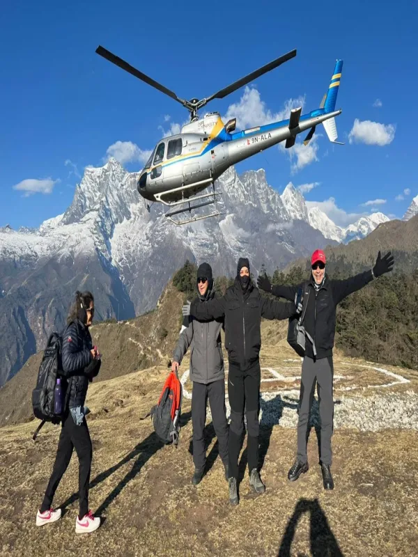 People clicking pictures at Everest base camp with helicopter at background